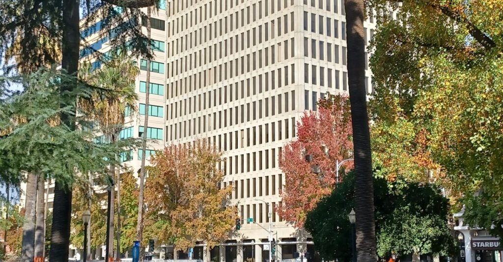 A vibrant autumn scene in downtown Sacramento with tall buildings surrounded by colorful trees.